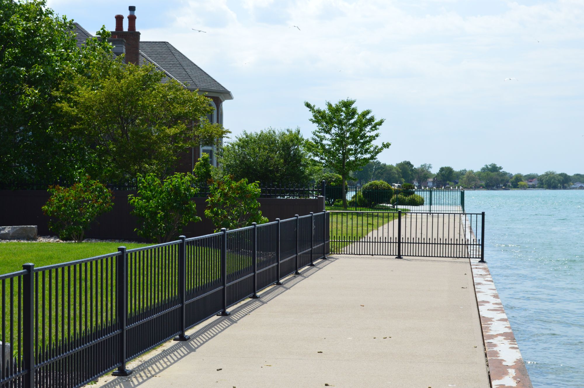 Bordering the Detroit River, this property has a stunning view. The homeowners had two small dogs that they needed to keep contained, so we built this custom design with puppy picket. Gloss Black aluminum fence with six-foot sections.